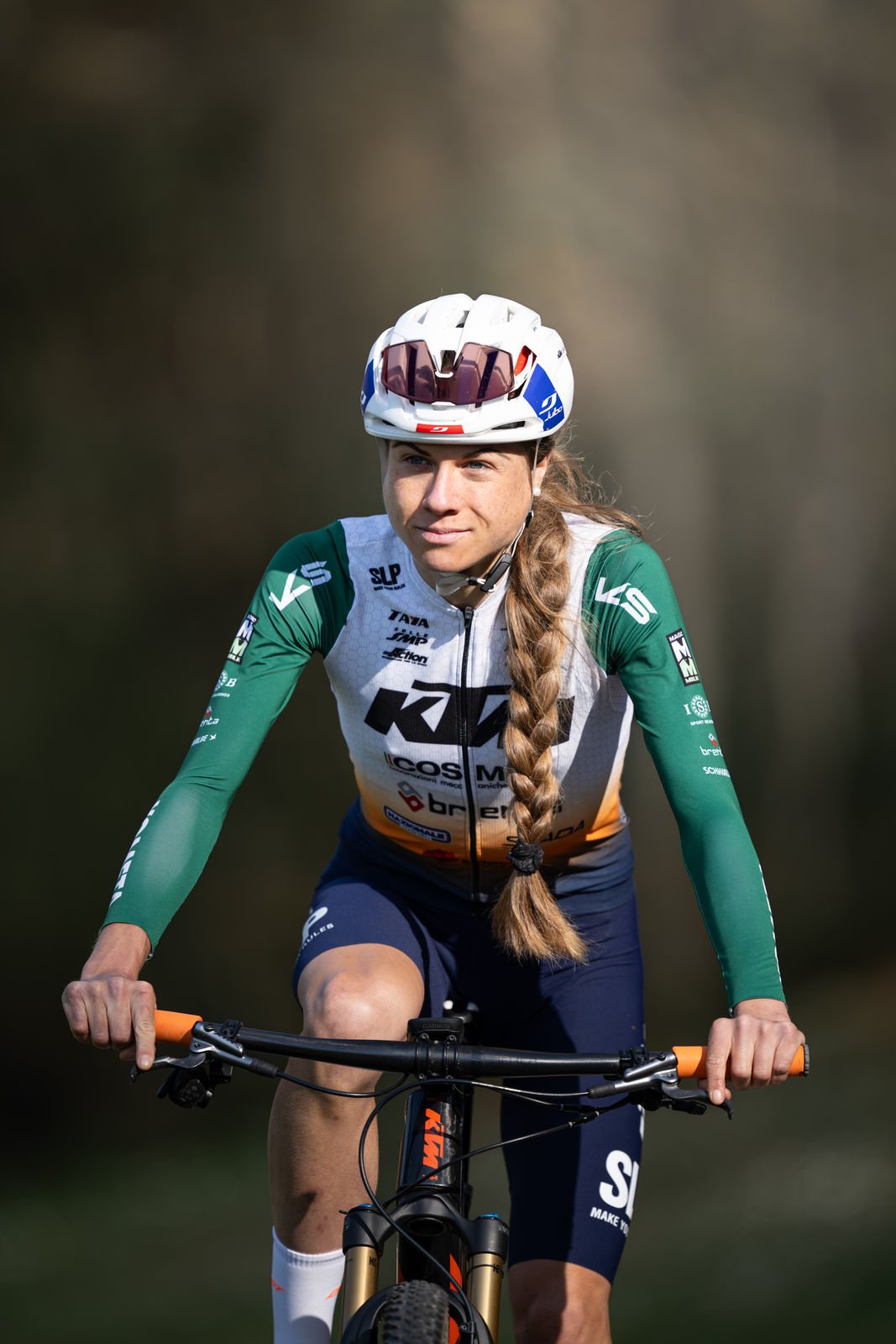 Anna Weinbeer auf dem Mountainbike, ruhiger Blick, dunkler Hintergrund