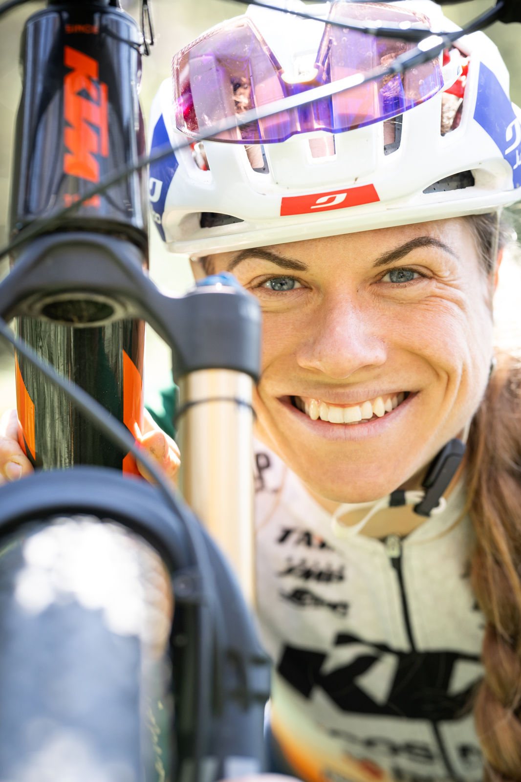 Anna Weinbeer lacht zwischen Velogabel und Speichen hindurch