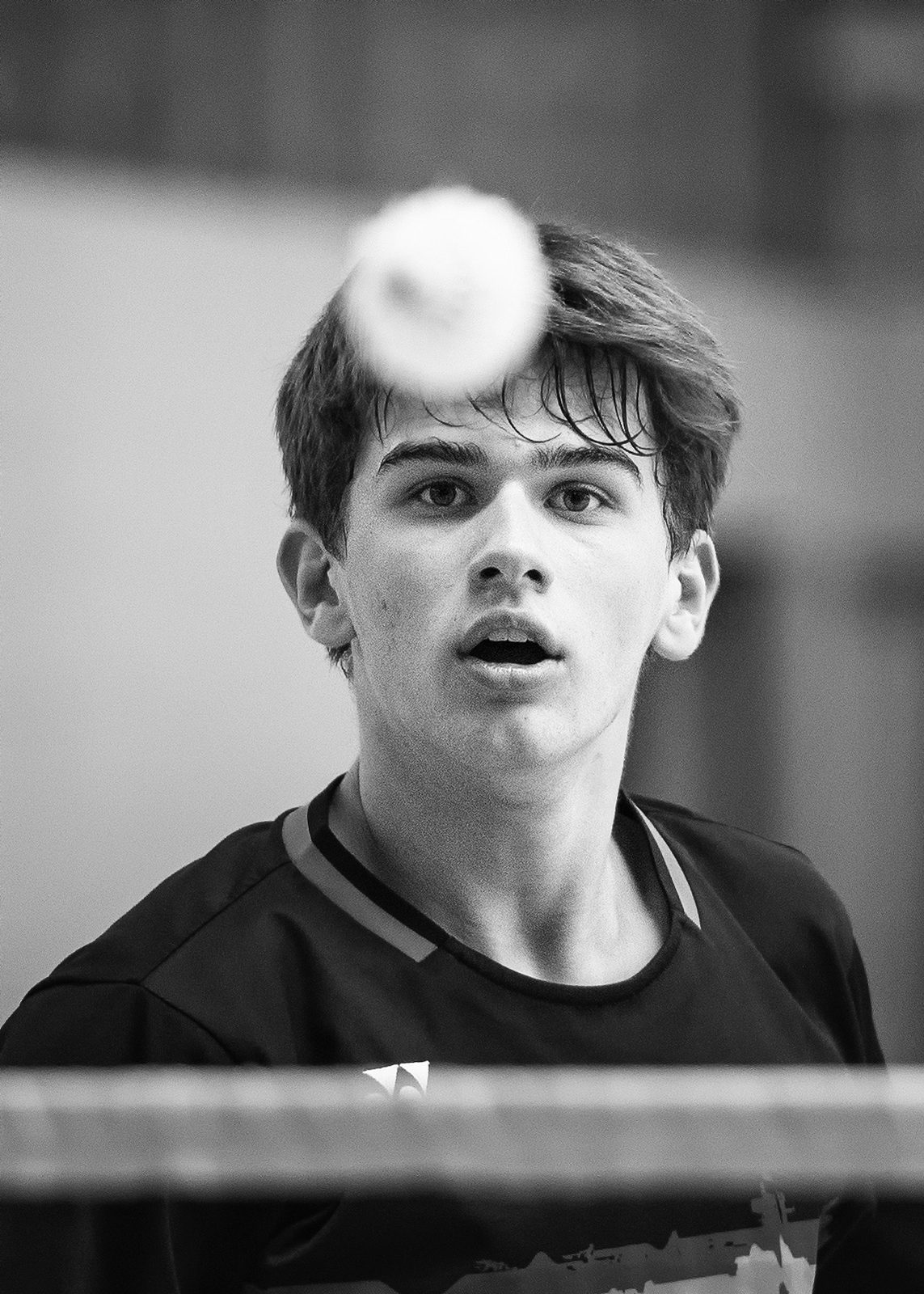 Badmintonspieler fixiert den Federball über dem Netz