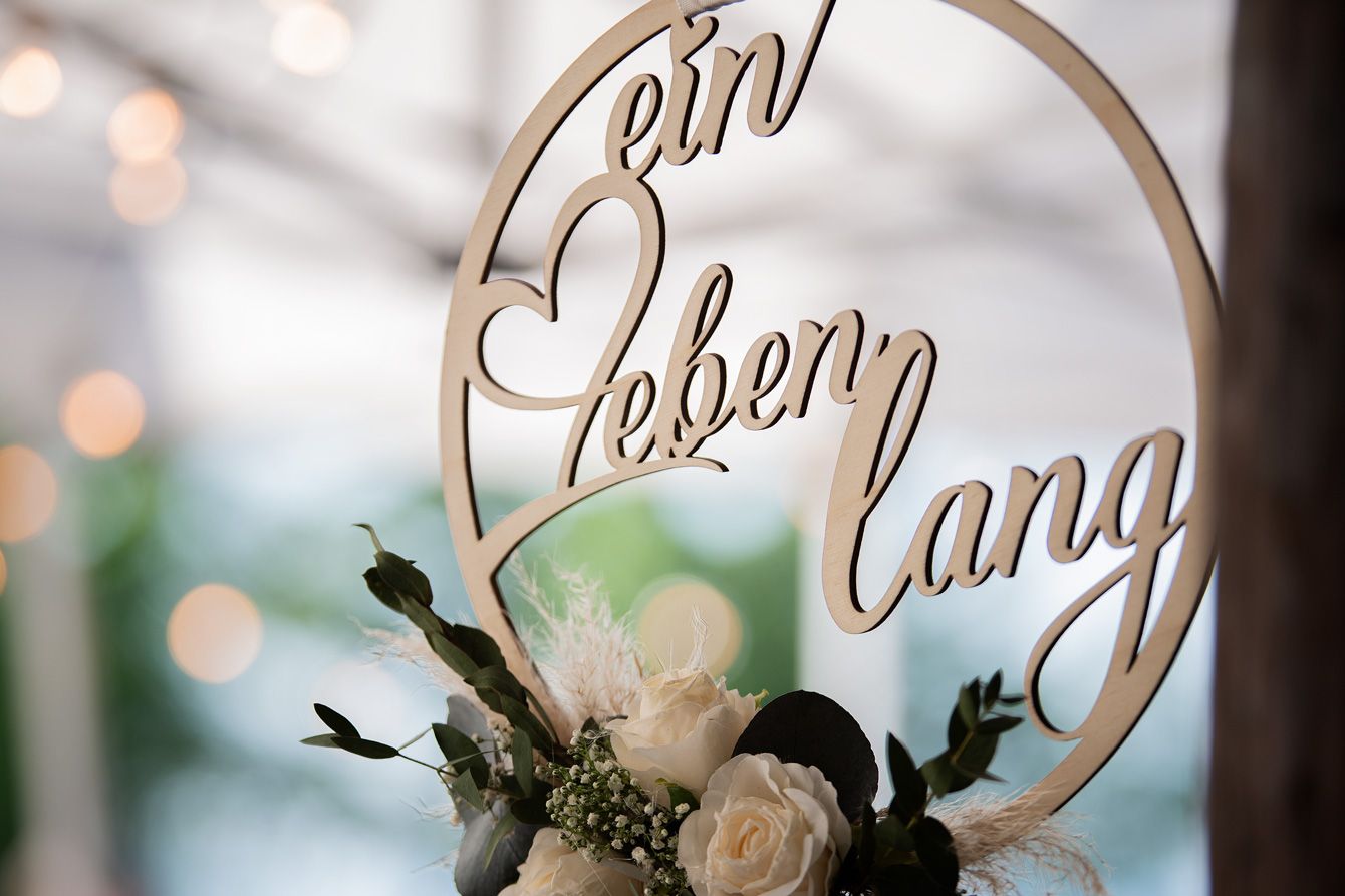 Holzring mit Schriftzug «ein Leben lang» und weissen Rosen