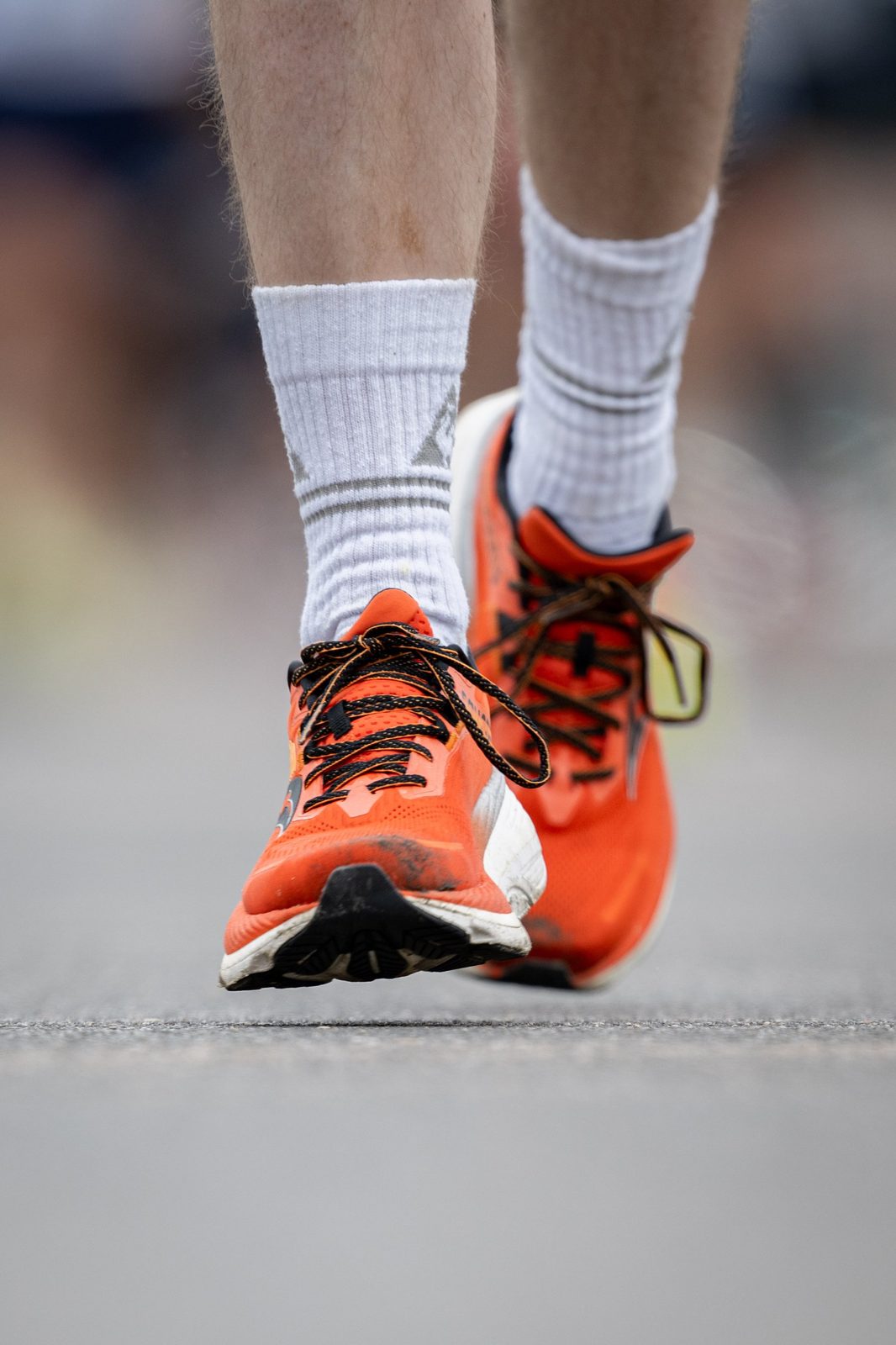 Orange Laufschuhe in Bewegung, Nahaufnahme auf der Strasse